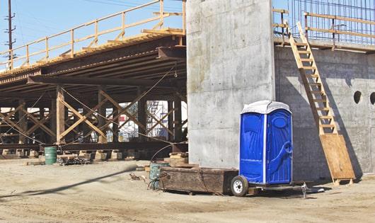 row of porta potties on a busy construction site